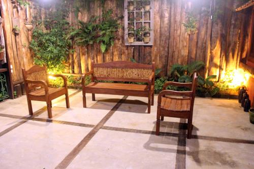 a room with three wooden chairs and a bench at Pousada Nova Gironda in Paty do Alferes
