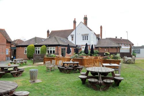 um grupo de mesas e cadeiras num pátio em White Hart by Chef & Brewer Collection em Chalfont Saint Giles