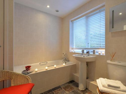 a bathroom with a bath tub and a sink at Min Y Mor in Llanfairpwllgwyngyll