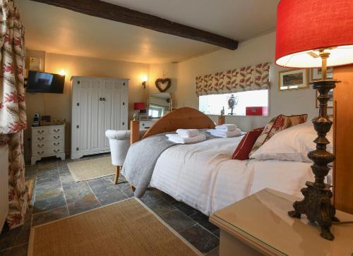 a bedroom with a bed and a table with a lamp at Holly Lodge Boutique B&B in Thursford