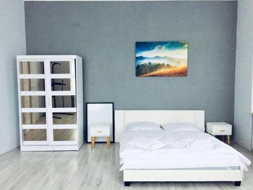 sypialnia z białym łóżkiem i lustrem w obiekcie Rebel Apartament w Bielsku Białej