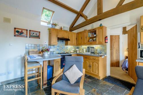eine Küche mit Holzschränken sowie einem Tisch und Stühlen in der Unterkunft Highgrove Barns in Craven Arms