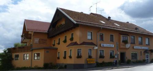 a large yellow building with a brown roof at Gasthof-Pension-Metzgerei Jäger in Michelsneukirchen