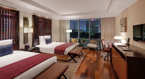 um quarto de hotel com duas camas e uma secretária em Kempinski Hotel Gold Coast City em Acra