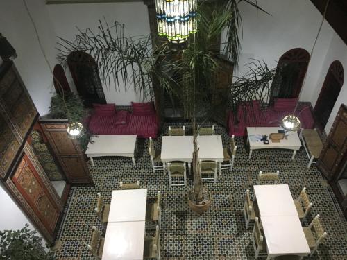 uitzicht op een restaurant met tafels en stoelen bij Dar Iman in Fès