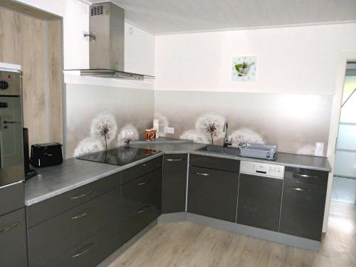 a kitchen with gray cabinets and stainless steel appliances at Ferienwohnung Kürmreuth in Königstein in der Oberpfalz