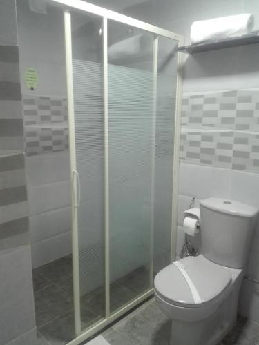 a bathroom with a toilet and a glass shower at Havana Hotel Cairo in Cairo