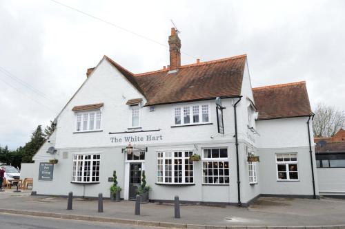a large white building with a clock on the front of it at White Hart by Chef & Brewer Collection in Chalfont Saint Giles
