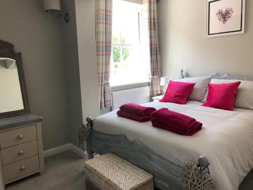 a bedroom with a bed with red pillows and a window at Boutique Townhouse in Christchurch Dorset in Christchurch