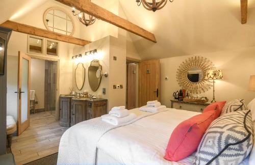 a bedroom with two beds and a bathroom with a sink at Holly Lodge Boutique B&B in Thursford