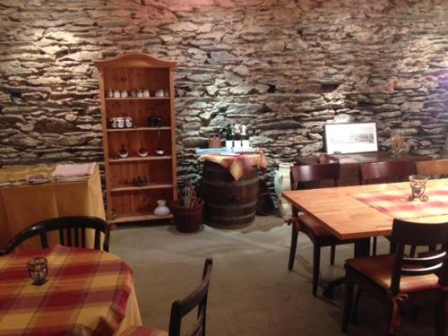 a dining room with a table and a stone wall at Weingut Endesfelder in Mehring