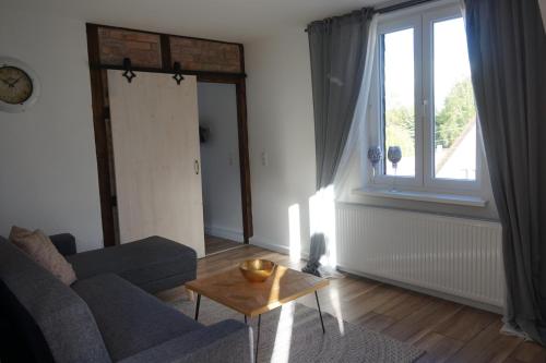 a living room with a couch and a table and a window at Ferienhaus Hundertmorgenfeld 33 in Wernigerode