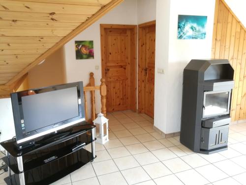 a living room with a flat screen tv and a entertainment center at Ferienwohnung Gross B in Schleiden