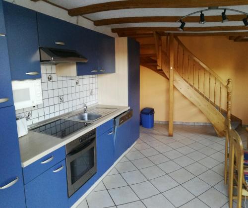 a kitchen with blue cabinets and a sink and a staircase at Ferienwohnung Gross B in Schleiden