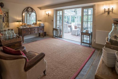 a living room with a chair and a table at Holly Lodge Boutique B&B in Thursford
