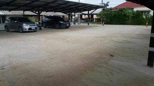 two cars are parked in a parking lot at ธนาวดี บูติคแอนด์ รีสอร์ท in Phetchaburi