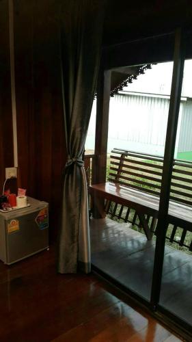 a room with a window with a bench and a table at ธนาวดี บูติคแอนด์ รีสอร์ท in Phetchaburi