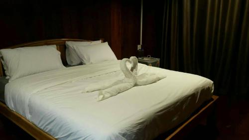 a towel animal is laying on a bed at ธนาวดี บูติคแอนด์ รีสอร์ท in Phetchaburi