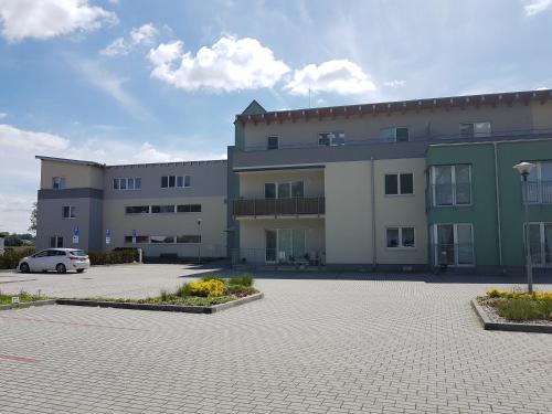 ein großes Gebäude mit einem Auto auf einem Parkplatz in der Unterkunft Apartmán 10 in Třeboň