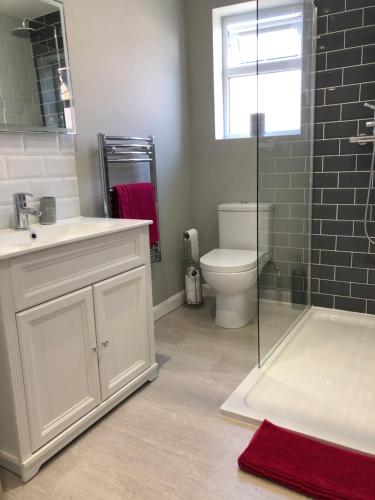 uma casa de banho com um WC, um lavatório e uma banheira em Boutique Townhouse in Christchurch Dorset em Christchurch