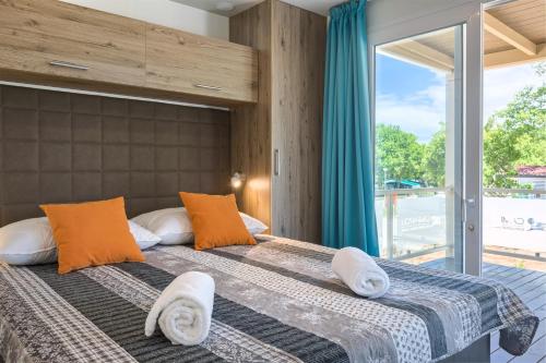 sypialnia z 2 łóżkami i dużym oknem w obiekcie Mobile Homes - Lanterna Premium Camping Resort w Poreču
