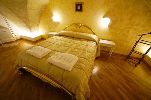 a bedroom with a bed with two towels on it at L' Infinito dei Sassi in Matera