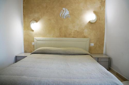 a bedroom with a bed with two nightstands and two lights at L' Infinito dei Sassi in Matera