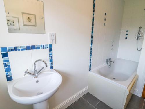 a bathroom with a sink and a bath tub at Langtree in Carnforth