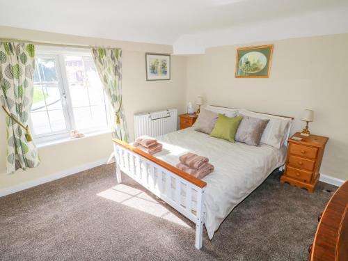 um quarto com uma cama branca e uma janela em The Cottage em Skegness