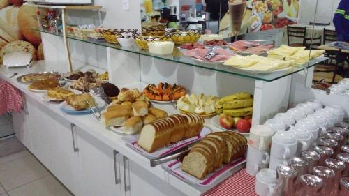 um buffet com muitos tipos diferentes de comida em exposição em Hotel DDC em Erechim