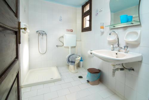 uma casa de banho branca com um lavatório e um WC em Irilena "by Checkin" em Gouves
