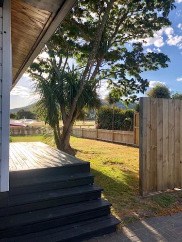 a house with stairs leading to a yard with a tree at Cosy n Central Rotorua 2BR Entire House & Studio -summer only in Rotorua