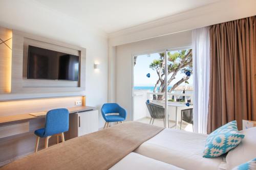 a hotel room with a bed and a view of the ocean at Grupotel Los Príncipes & Spa in Playa de Muro