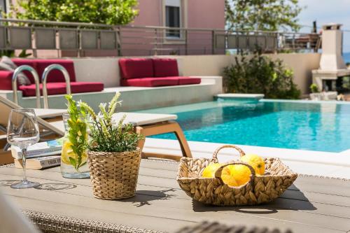 a table with baskets of fruit on a table near a pool at Athinais LAK Villa in Lakithra