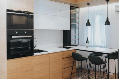 a kitchen with black and white appliances and bar stools at Apartments Trifunovic Old Town in Budva