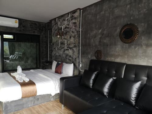 a bedroom with a bed and a couch at Keeree Loft Resort คีรีลอฟท์รีสอร์ท in Thong Pha Phum