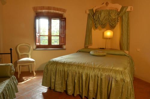 1 dormitorio con cama, ventana y silla en Il Cardo Resort, en Anghiari