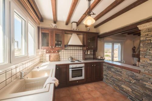 a large kitchen with a tub and a sink at Villa Arokaria in Stení