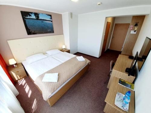 a hotel room with a bed and a desk at Hotel Mazuria Country & SPA in Mrągowo