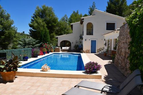 a swimming pool in front of a house at Casa Romero in Lliber