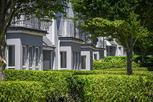 a row of white houses with trees and bushes at Mount Wolseley Hotel Spa & Golf Resort in Tullow