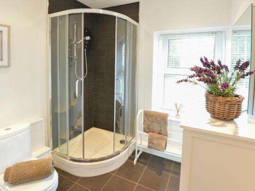 a glass shower in a bathroom with a chair at 12 Victoria Terrace in Nantlle