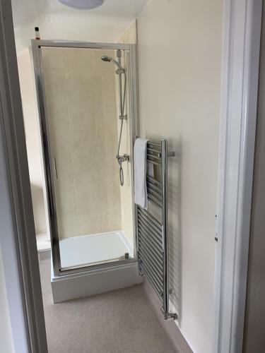 a shower with a glass door in a bathroom at The Queens Head in Stratford-upon-Avon
