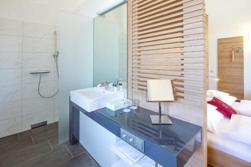 
a bathroom with a sink, mirror, and bathtub at Hotel Altes Kloster in Hainburg an der Donau
