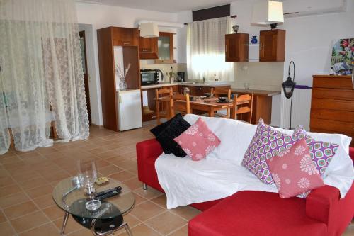 a living room with a red couch and a kitchen at Marilia Home in Kounoupidhianá
