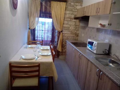 a kitchen with a table with chairs and a microwave at APP GAŠI in Buje