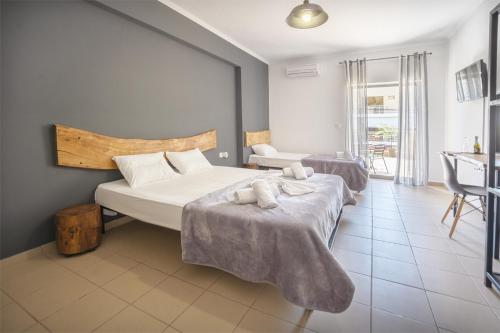 a hotel room with two beds and a bathroom at Saffroni Inn in Paralia Katerinis