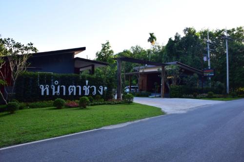 a building with a sign on the side of a road at Nao Ta Chuang in Thung Song