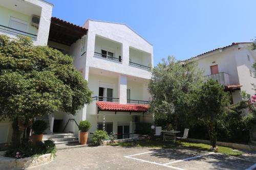 an apartment building with a parking lot and trees at Elia in Skála Foúrkas