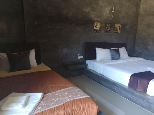 two beds sitting next to each other in a room at Keeree Loft Resort คีรีลอฟท์รีสอร์ท in Thong Pha Phum